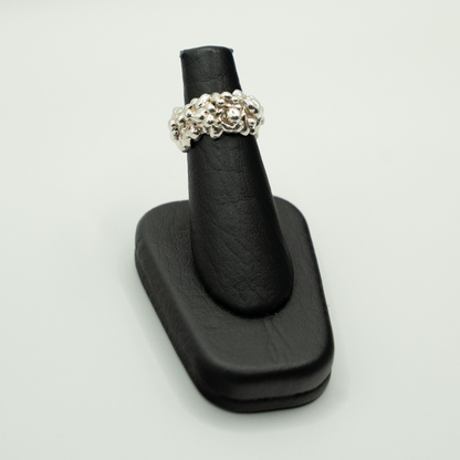 Silver ring on a black ring holder against a white background