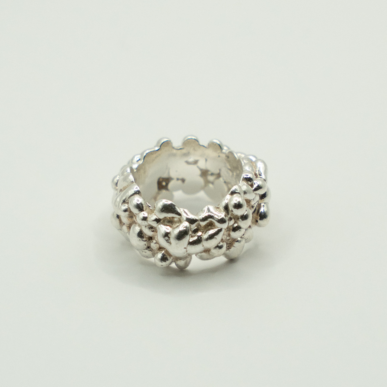 Silver textured bead on a light gray background